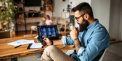 man-baard-kijkt-thuis-op-telefoon