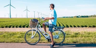 Fietser in korte broek bij windmolenveld