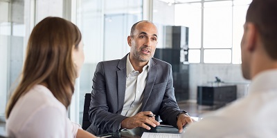 man-met-echtpaar-gesprek-tafel