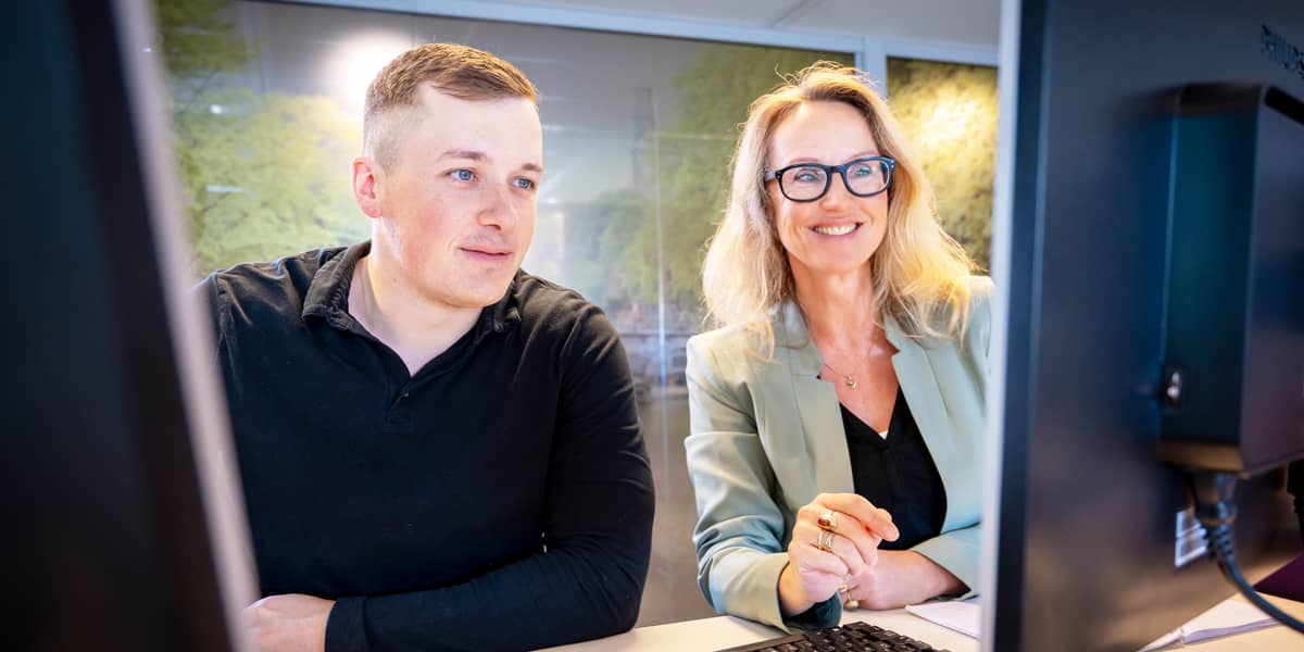 Twee mensen kijken naar computerschermen
